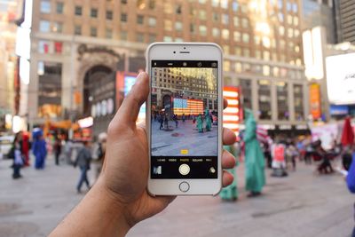 Cropped image of woman photographing through smart phone