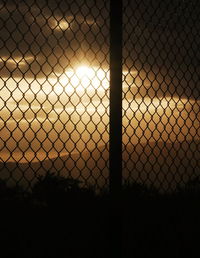Close-up of chainlink fence at sunset