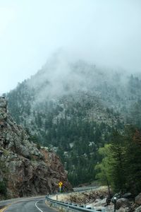 Scenic view of rocky mountains in foggy weather
