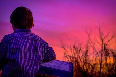 Rear view of man against sky during sunset