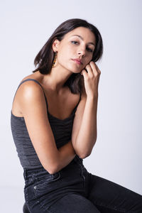 Pretty girl posing in a studio with a grey backdrop