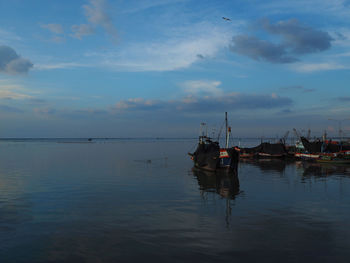 Fishing boat in sea against sky