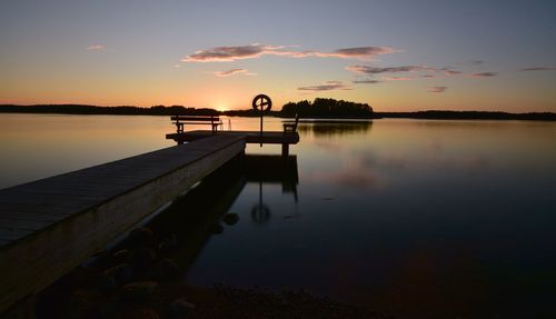 Pier on lake at sunset