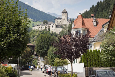 Houses and trees in city against sky