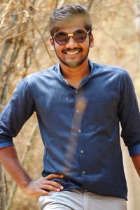 Portrait of young man wearing sunglasses while standing outdoors