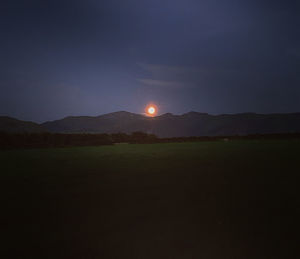 Scenic view of field against clear sky at night