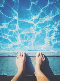 Low section of man relaxing in swimming pool