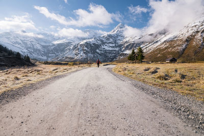 Road amidst snowcapped mountains against sky