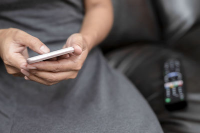 Midsection of man using mobile phone