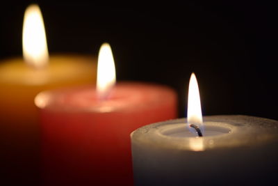 Close-up of lit candle in the dark