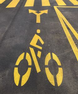 High angle view of yellow bicycle sign on road