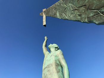 Low angle view of statue against clear blue sky