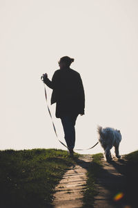 Rear view of man walking on snow