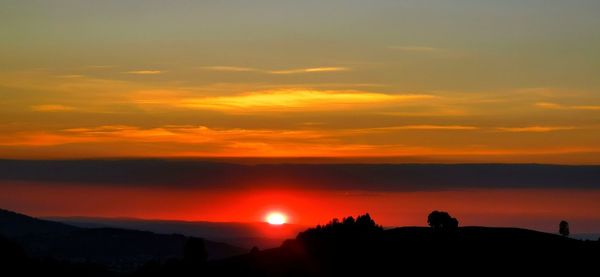 Scenic view of silhouette mountain against orange sky