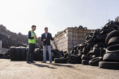 Mature businessman discussing over rubber tires with colleague