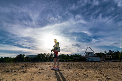 Full length of woman standing on field against sky