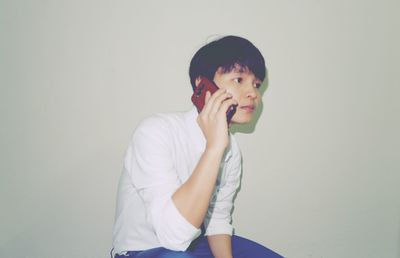 Portrait of boy standing against wall