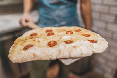 Close-up of hand holding pizza