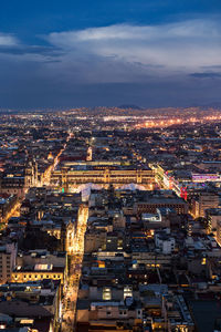 High angle view of illuminated city against sky at dusk