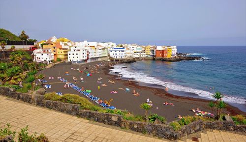 High angle view of buildings by sea against sky