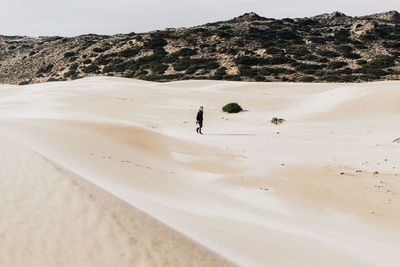 Man walking on sand dune in desert