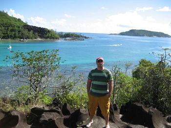 Portrait of man standing in sea against sky