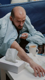 Portrait of man using mobile phone while sitting on table