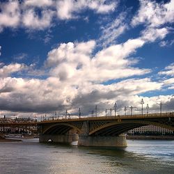 Bridge over river against cloudy sky