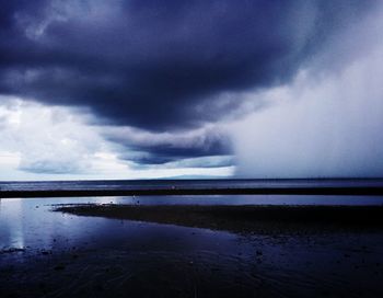 Scenic view of sea against storm clouds