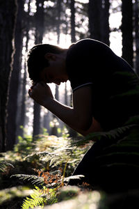 Side view of young woman in forest