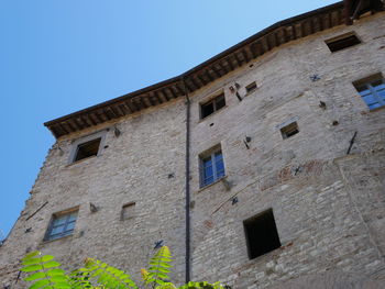 Low angle view of old building against clear blue sky