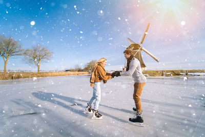 Full length of woman standing on snow covered field