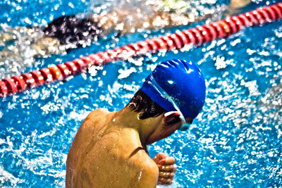 Rear view of swimmer swimming in pool