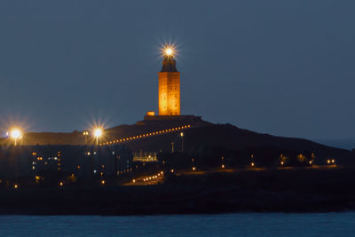 Illuminated buildings against sky at night, hércules tower against sky.