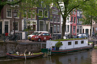 Boats moored in canal by buildings in city