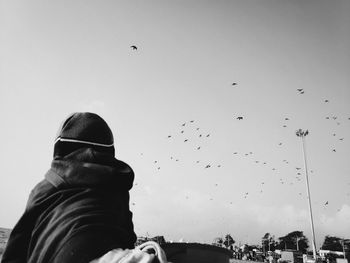 Low angle view of man flying against sky