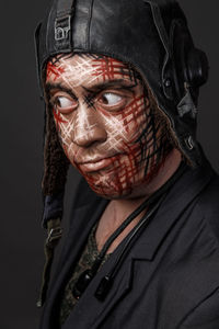 Close-up of man with face paint against black background