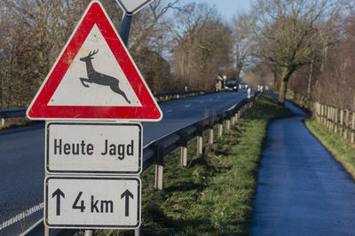 Close-up of road sign against trees