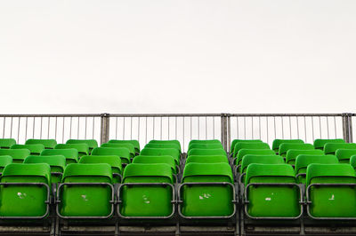 Green bleachers at stadium against clear sky