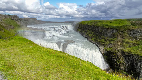 Scenic view of waterfall against sky