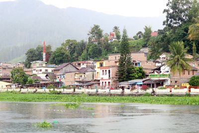 Houses by river and buildings in city