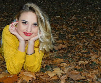 Portrait of a beautiful young woman with autumn leaves