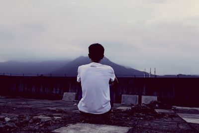 Rear view of a man standing against the sky