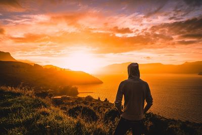 Rear view of man looking at sunset