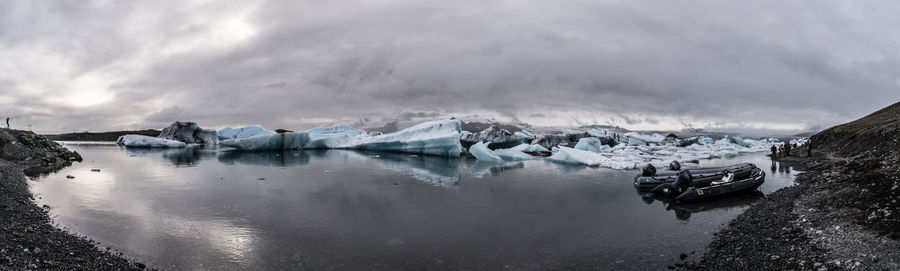 Panoramic view of frozen lake against sky