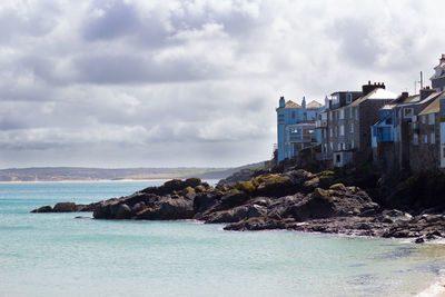 Scenic view of sea by buildings against sky