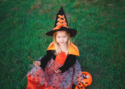 Portrait of smiling girl wearing costume on grassy field