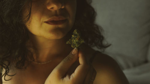 Close-up portrait of a young woman holding flower