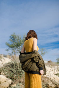 Rear view of woman standing against sky