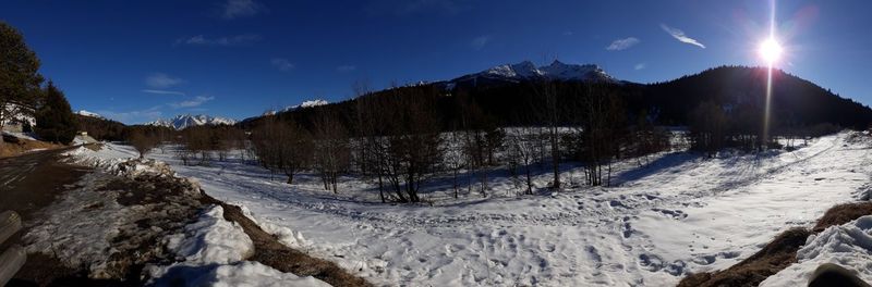 Panoramic view of snow covered mountains against sky